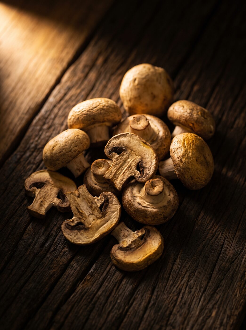 Dried button mushrooms on dark teak